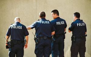 4 policemen with backs to the camera